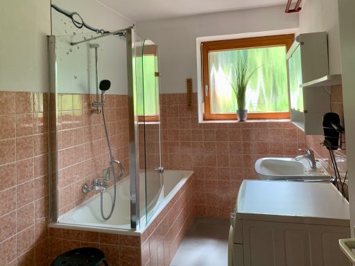 Bad Modernes Bad mit Duschbereich, Badewanne und Waschbecken in hellen Farben.